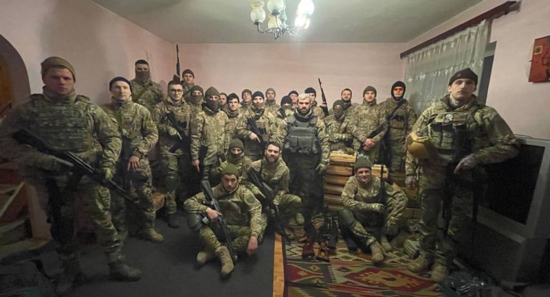 photo of room full of men in camo with weapons
